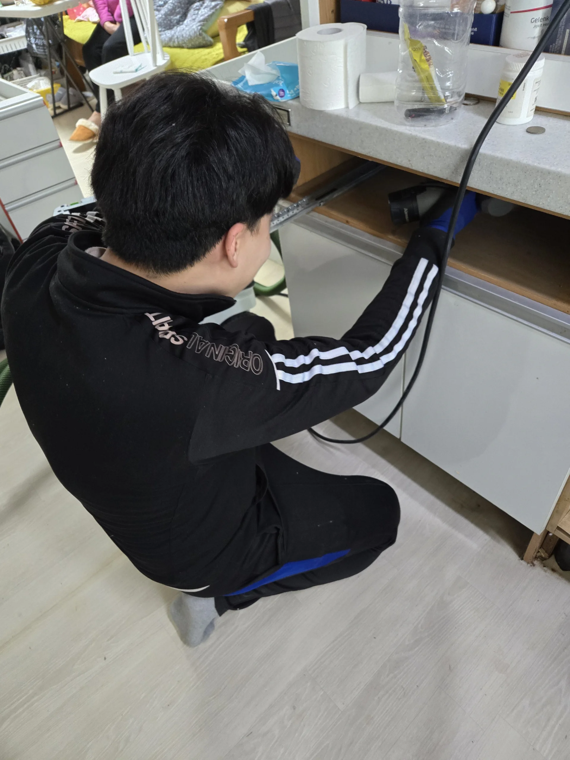 싱크대 수리 교육 청소기를 들고 하부장 내부를 정리하는 실습 실제 수강 사진
